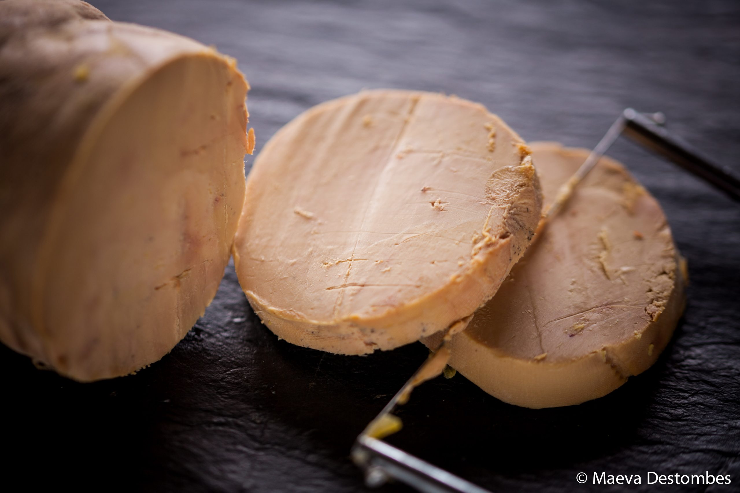 Des tranches de foie gras coupées avec une guillotine