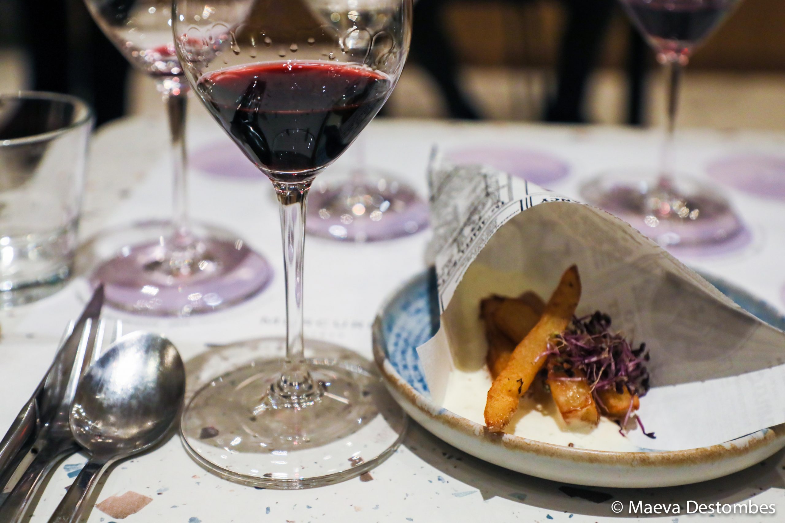 Une table avec une assiette de nourriture et des verres à vin.